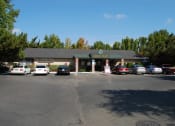 Thumbnail 12 of 12 - a parking lot in front of a building with cars parked