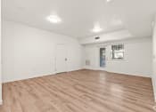 Thumbnail 9 of 12 - an empty living room with white walls and wood floors
