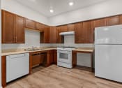 Thumbnail 5 of 12 - a kitchen with white appliances and wooden cabinets