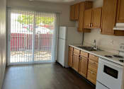 Thumbnail 2 of 7 - an empty kitchen with a sliding glass door to a patio