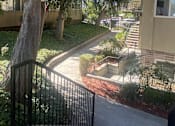 Thumbnail 14 of 16 - an apartment building with stairs and a sidewalk and trees