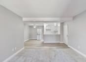 Thumbnail 15 of 30 - an empty living room with a kitchen in the background at Brookhollow Apartments, West Covina , CA