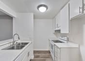 Thumbnail 19 of 30 - an empty kitchen with white cabinets and a sink at Brookhollow Apartments, West Covina , CA