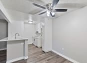 Thumbnail 16 of 30 - an open kitchen and living room with a ceiling fan at Brookhollow Apartments, West Covina , California