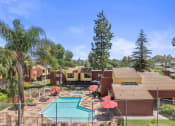 Thumbnail 24 of 30 - an aerial view of a resort with a pool and umbrellas at Brookhollow Apartments, California, 91792
