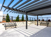 Thumbnail 8 of 17 - A patio with a bench and a roof.