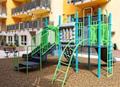 Thumbnail 17 of 17 - A playground with a green slide and a blue bench.