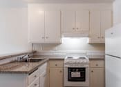 Thumbnail 4 of 16 - a kitchen with white cabinets and white appliances and granite counter tops