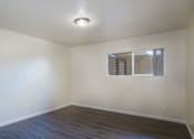 Thumbnail 7 of 16 - an empty living room with white walls and a window
