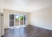 Thumbnail 6 of 16 - an empty living room with a sliding glass door to a patio