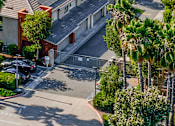 Thumbnail 8 of 20 - an aerial view of a parking lot with cars and palm trees