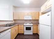Thumbnail 18 of 20 - a kitchen with white appliances and wooden cabinets