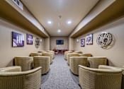 Thumbnail 11 of 20 - a movie room with large television filled with couch seating