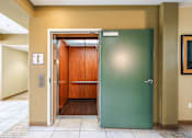 Thumbnail 16 of 20 - an elevator with a green door