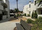 Thumbnail 27 of 44 - a bench on a sidewalk in front of some buildings