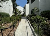 Thumbnail 22 of 44 - a path between two buildings with black railings