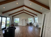 Thumbnail 37 of 44 - a club room with a vaulted ceiling and wood floors