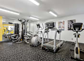 Thumbnail 3 of 20 - A gym with a variety of equipment including treadmills, weights, and exercise machines.