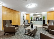 Thumbnail 5 of 20 - A conference room with brown chairs and a wooden door.