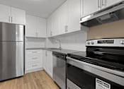 Thumbnail 11 of 20 - A kitchen with a stainless steel refrigerator, a stove, and white cabinets.