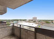 Thumbnail 20 of 20 - A view from a balcony overlooking a parking lot and buildings.