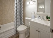 Thumbnail 23 of 24 - A white toilet sits next to a white sink in a bathroom.