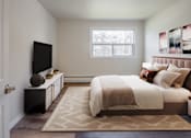 Thumbnail 21 of 24 - A bedroom with a large bed and a flat screen TV.