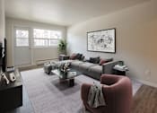 Thumbnail 19 of 24 - A living room with a grey sofa and a red armchair.