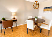 Thumbnail 8 of 11 - A dining room with a round table and chairs.