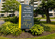 Thumbnail 1 of 11 - A sign for Osgood Apartments is in front of a building.