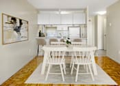 Thumbnail 5 of 14 - A dining room with a white table and chairs.