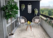 Thumbnail 8 of 8 - A balcony with two chairs and a table.
