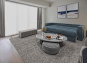 Thumbnail 2 of 8 - A living room with a grey sofa, a grey coffee table, and a grey ottoman.