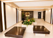 Thumbnail 7 of 11 - A long hallway with a bench and a flower arrangement in the middle.