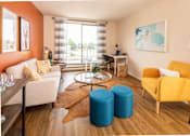 Thumbnail 8 of 24 - A living room with a yellow chair and blue ottomans.