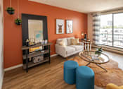 Thumbnail 9 of 24 - A living room with a white sofa, a glass coffee table, and a wooden floor.