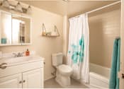 Thumbnail 13 of 24 - A white bathroom with a white toilet and sink.