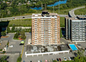 Thumbnail 1 of 9 - A large building with a pool in front of it.