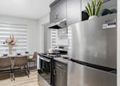 Thumbnail 13 of 34 - A modern kitchen with a dining table set for four.