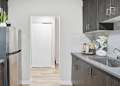 Thumbnail 10 of 34 - A kitchen with a white refrigerator and wooden cabinets.