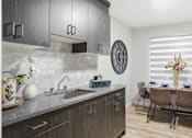 Thumbnail 7 of 34 - A modern kitchen with a dining table set for two.