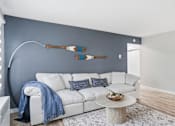 Thumbnail 11 of 34 - A white couch with a blue throw blanket on it.