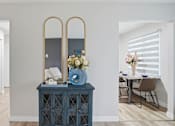 Thumbnail 14 of 34 - A blue cabinet with a mirror and flowers on top.
