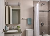 Thumbnail 14 of 20 - A white toilet sits next to a sink in a bathroom.