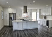 Thumbnail 49 of 52 - a kitchen with white cabinets and a large center island