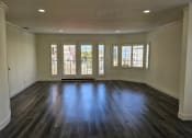 Thumbnail 46 of 52 - an empty living room with wooden floors and windows
