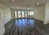 Thumbnail 36 of 52 - an empty living room with wooden floors and windows