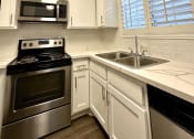 Thumbnail 15 of 29 - a kitchen with stainless steel appliances and white cabinets