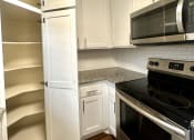 Thumbnail 16 of 29 - a kitchen with white cabinets and a black stove