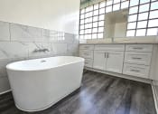 Thumbnail 40 of 52 - a large white bathroom with a large tub in the center